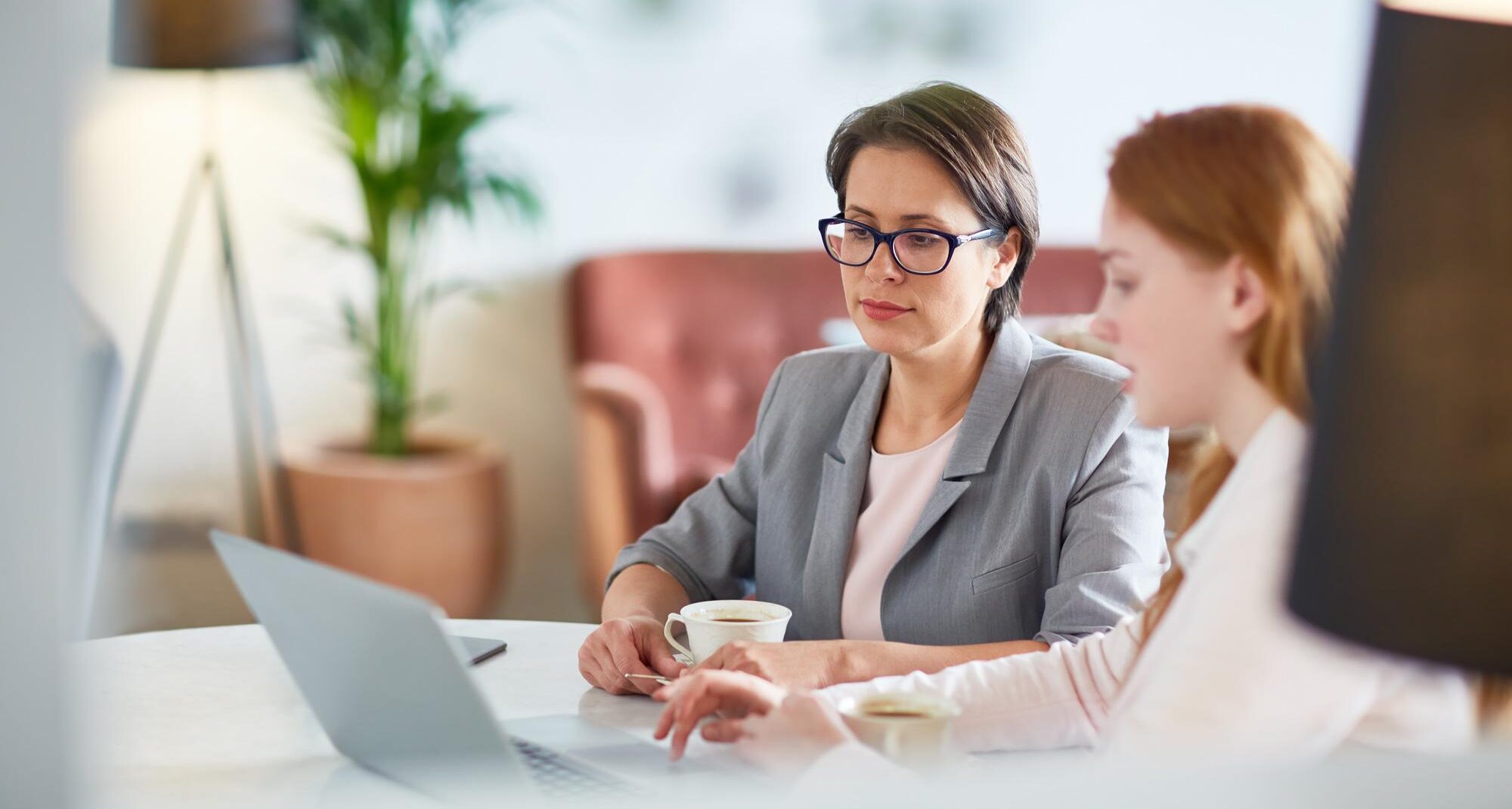 deux femmes dans les locaux d'une entreprise regarde un ordinateur